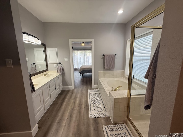5038 Fawn Lake Dr, San Antonio, TX 78244 - bathroom featuring a sink, a garden tub, ceiling fan, double vanity, and wood finished floors