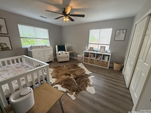 5038 Fawn Lake Dr, San Antonio, TX 78244 - bedroom with baseboards, visible vents, a crib, ceiling fan, and wood finished floors