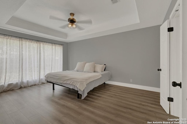 5038 Fawn Lake Dr, San Antonio, TX 78244 - bedroom with a raised ceiling, baseboards, ceiling fan, and wood finished floors