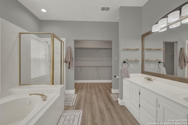 5038 Fawn Lake Dr, San Antonio, TX 78244 - full bathroom with visible vents, a shower stall, wood finished floors, a sink, and a garden tub