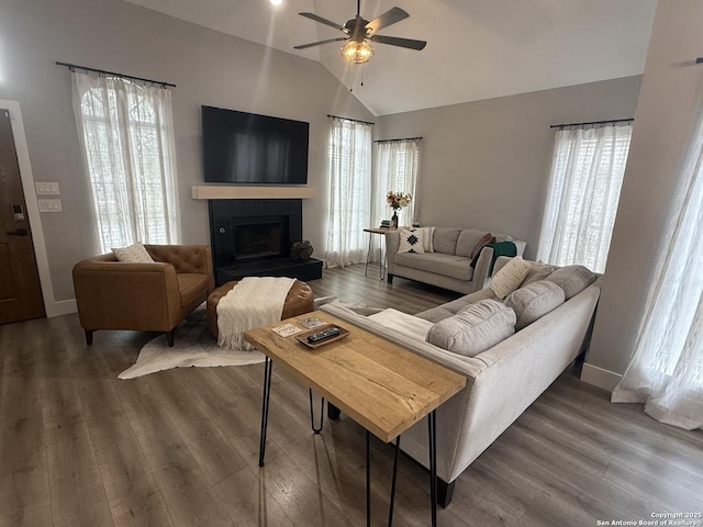 5038 Fawn Lake Dr, San Antonio, TX 78244 - living area with vaulted ceiling, a fireplace with raised hearth, baseboards, a ceiling fan, and wood finished floors