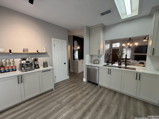 5038 Fawn Lake Dr, San Antonio, TX 78244 - kitchen with light countertops, visible vents, dishwasher, light wood-style floors, and an inviting chandelier