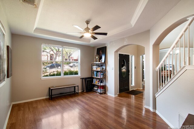 19423 Camino Rdg, San Antonio, TX 78258 - entrance foyer with arched walkways, a tray ceiling, ceiling fan, and wood finished floors