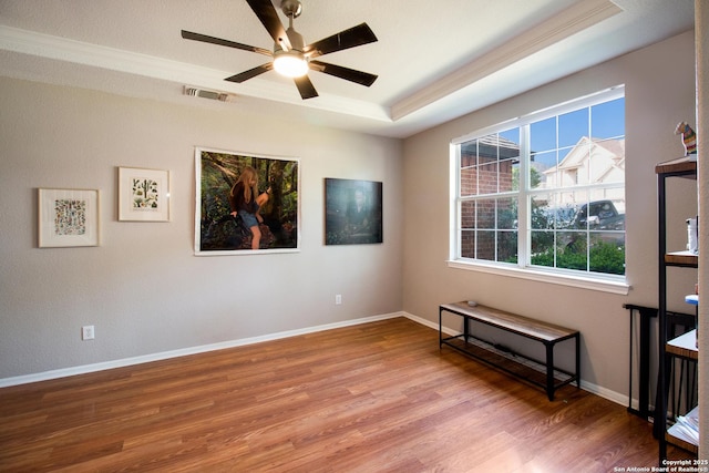 19423 Camino Rdg, San Antonio, TX 78258 - empty room featuring crown molding, wood finished floors, a ceiling fan, a raised ceiling, and baseboards