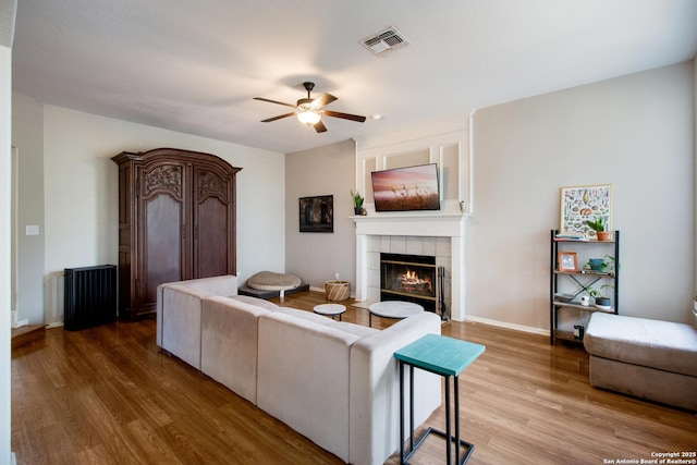 19423 Camino Rdg, San Antonio, TX 78258 - living room featuring ceiling fan, a tile fireplace, light wood-type flooring, and baseboards
