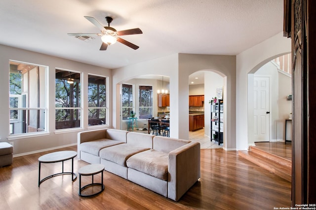 19423 Camino Rdg, San Antonio, TX 78258 - living room with light wood-type flooring, arched walkways, baseboards, and a ceiling fan