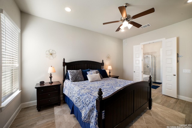 bedroom with light wood-type flooring, connected bathroom, baseboards, and visible vents