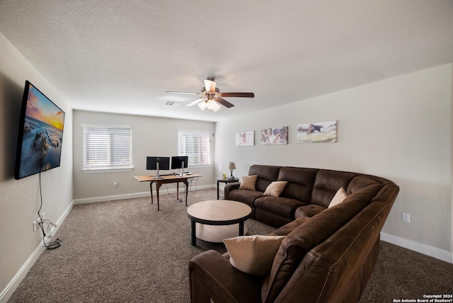 carpeted living room with a textured ceiling, baseboards, and ceiling fan
