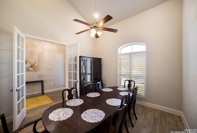 dining room with high vaulted ceiling, baseboards, ceiling fan, wood finished floors, and french doors