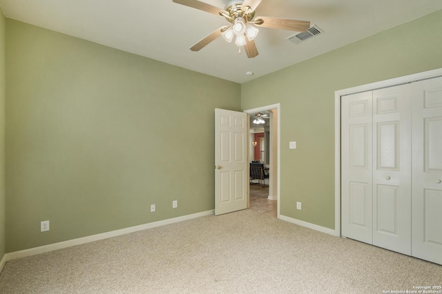 unfurnished bedroom featuring a ceiling fan, visible vents, baseboards, a closet, and light carpet