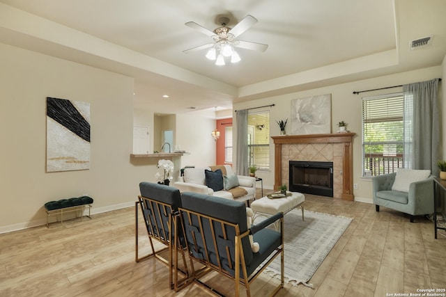 living room with plenty of natural light, a ceiling fan, hardwood / wood-style flooring, and visible vents