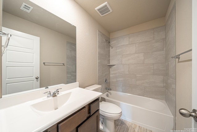 bathroom featuring wood finished floors, visible vents, toilet, and vanity