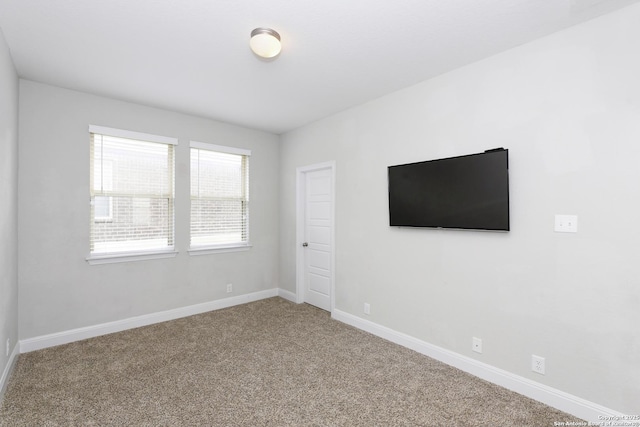 empty room featuring carpet floors and baseboards