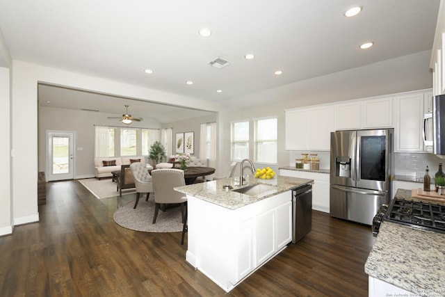 kitchen with decorative backsplash, dark wood-style flooring, a sink, and stainless steel appliances