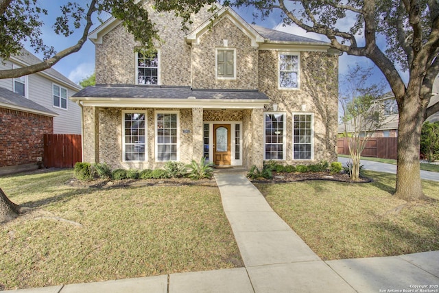 traditional home featuring fence and a front lawn