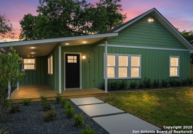 view of front facade featuring board and batten siding and a lawn