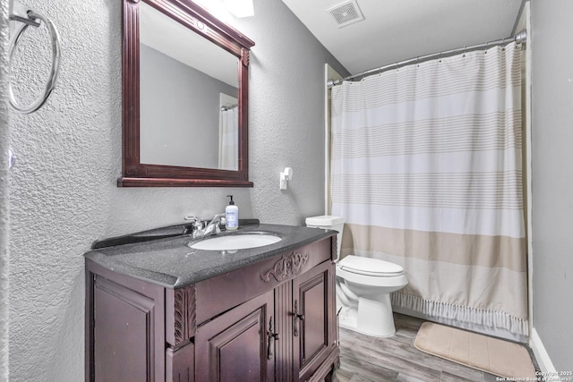 24704 Killarney St, Hempstead, TX 77445 - bathroom featuring a textured wall, visible vents, toilet, vanity, and wood finished floors