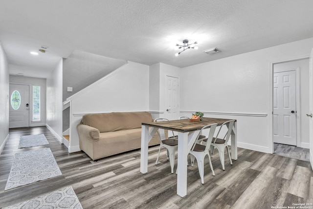 24704 Killarney St, Hempstead, TX 77445 - dining space with a textured ceiling, wood finished floors, visible vents, and baseboards