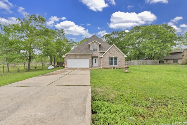 24704 Killarney St, Hempstead, TX 77445 - traditional-style home with driveway, fence, brick siding, an attached garage, and a front yard