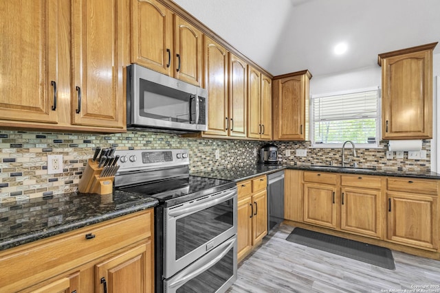 24704 Killarney St, Hempstead, TX 77445 - kitchen with dark stone countertops, a sink, decorative backsplash, stainless steel appliances, and light wood finished floors