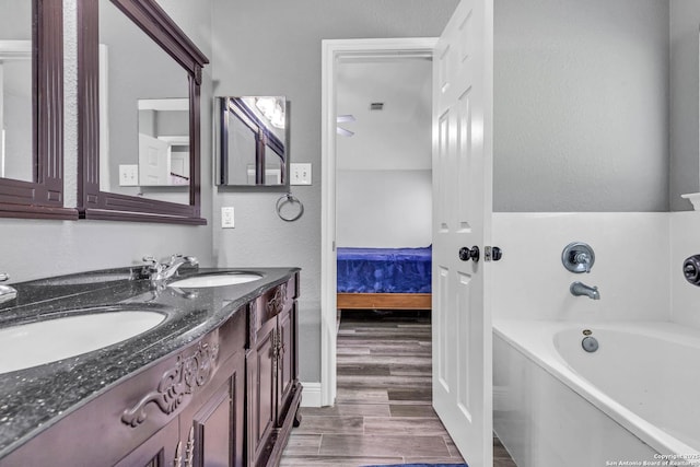 24704 Killarney St, Hempstead, TX 77445 - bathroom with a tub to relax in, wood finished floors, ensuite bath, and a sink