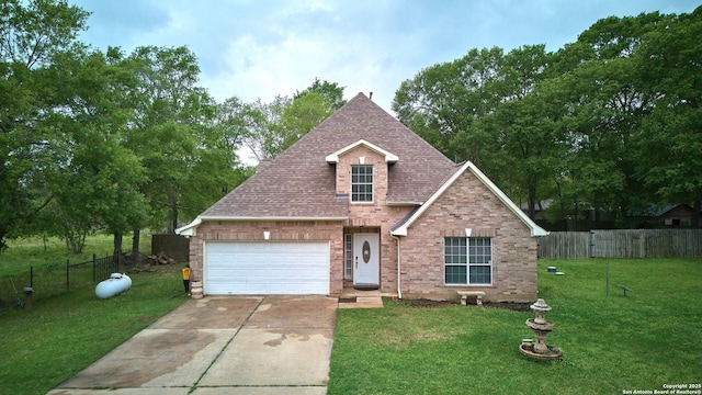 24704 Killarney St, Hempstead, TX 77445 - traditional home with concrete driveway, fence, brick siding, a shingled roof, and a front yard