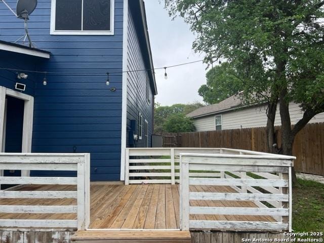 view of side of property featuring a deck and fence
