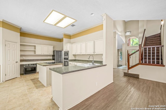 15338 Winter Mist Dr, San Antonio, TX 78247 - kitchen featuring open shelves, visible vents, black appliances, a center island, and a sink