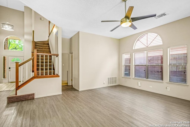 15338 Winter Mist Dr, San Antonio, TX 78247 - unfurnished living room with stairs, visible vents, ceiling fan, and wood finished floors