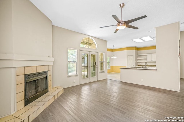 15338 Winter Mist Dr, San Antonio, TX 78247 - unfurnished living room featuring light wood-style flooring, ceiling fan, baseboards, and a fireplace