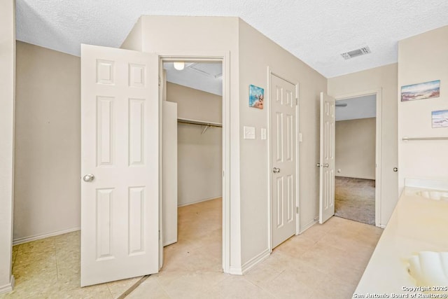 15338 Winter Mist Dr, San Antonio, TX 78247 - hall with visible vents, a textured ceiling, and baseboards