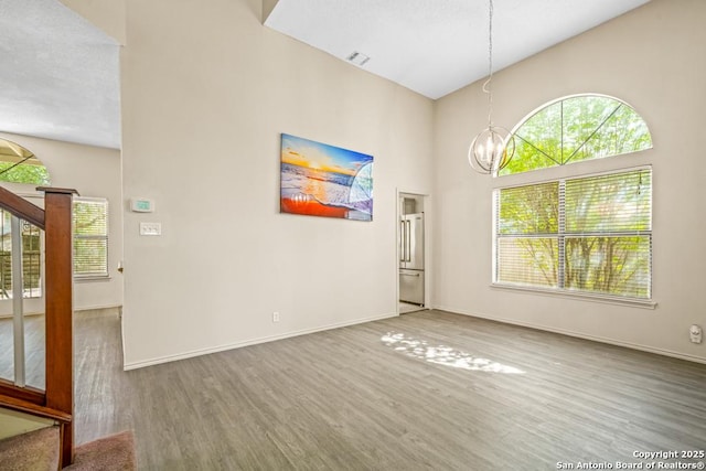15338 Winter Mist Dr, San Antonio, TX 78247 - spare room with visible vents, a high ceiling, an inviting chandelier, wood finished floors, and stairs