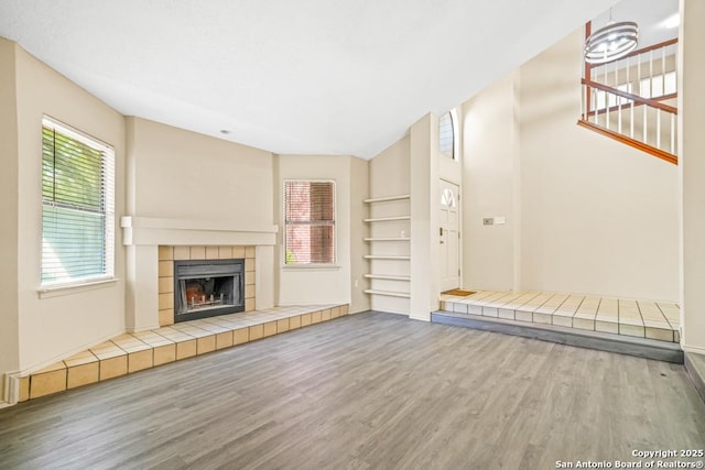 15338 Winter Mist Dr, San Antonio, TX 78247 - unfurnished living room featuring a tiled fireplace and wood finished floors