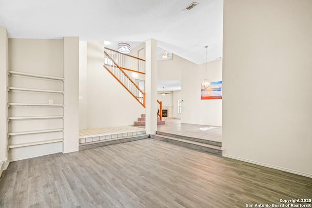 15338 Winter Mist Dr, San Antonio, TX 78247 - unfurnished living room featuring visible vents, stairway, wood finished floors, lofted ceiling, and baseboards
