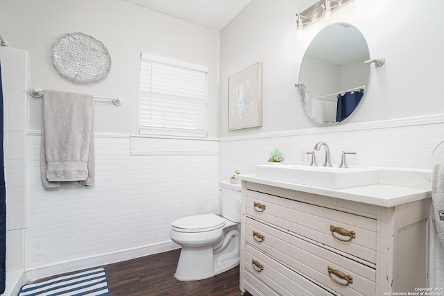 full bath featuring vanity, a shower with curtain, a wainscoted wall, toilet, and wood finished floors