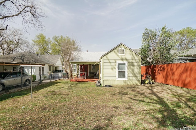 back of house featuring central air condition unit, fence private yard, and a lawn