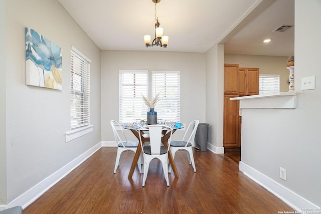 dining room with dark wood-style floors, baseboards, an inviting chandelier, and visible vents