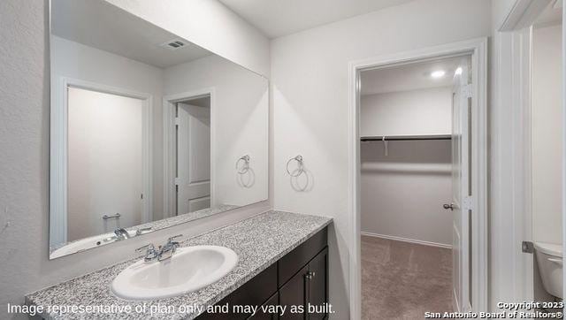 1506 Champagne Oak, New Braunfels, TX 78130 - bathroom featuring vanity, toilet, baseboards, a spacious closet, and visible vents