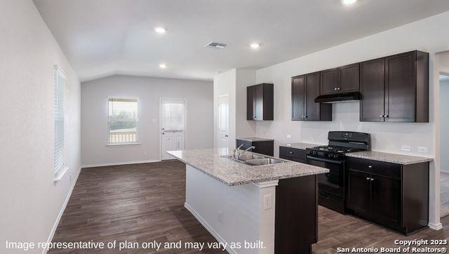 1506 Champagne Oak, New Braunfels, TX 78130 - kitchen featuring visible vents, a sink, black gas range oven, under cabinet range hood, and dark wood-type flooring