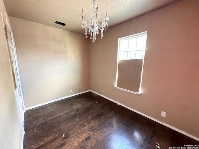 934 Iowa, San Antonio, TX 78203 - empty room featuring a textured ceiling, dark wood-style flooring, a notable chandelier, and baseboards