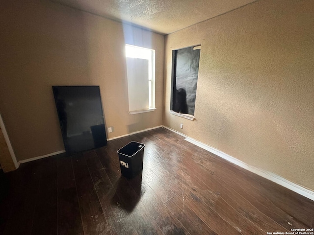 934 Iowa, San Antonio, TX 78203 - spare room featuring a textured wall, dark wood-style flooring, a textured ceiling, and baseboards
