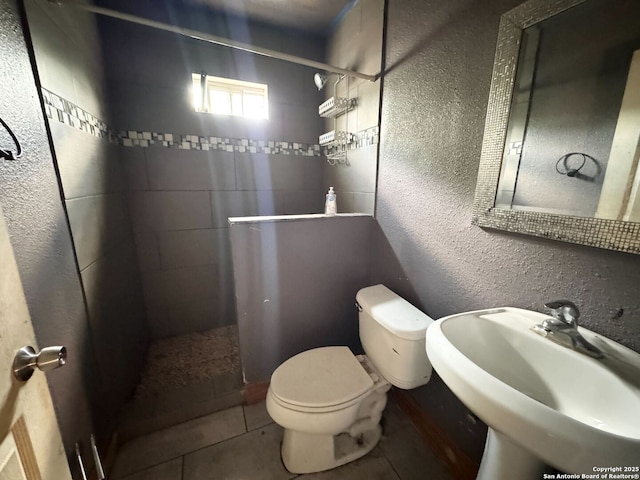 934 Iowa, San Antonio, TX 78203 - full bath featuring toilet, tiled shower, a textured wall, and a sink