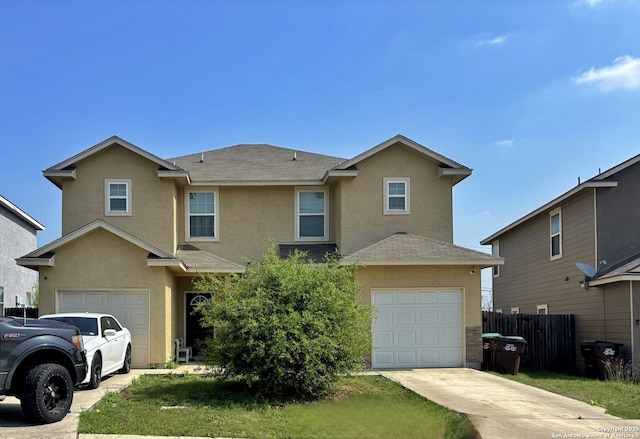 traditional-style home featuring a shingled roof, a garage, fence, stucco siding, and driveway