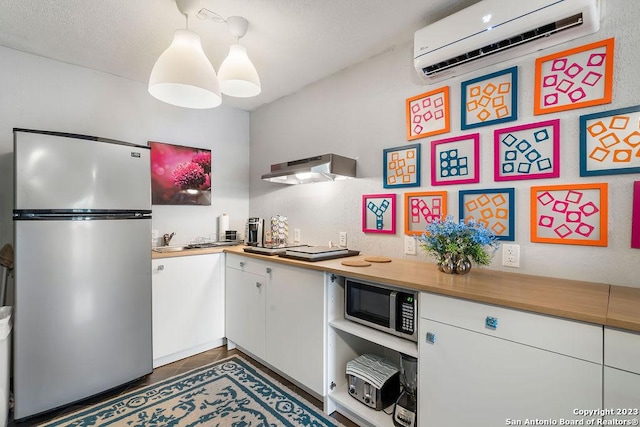 4935 Driskill St, San Antonio, TX 78228 - kitchen featuring stainless steel appliances, under cabinet range hood, white cabinets, and a wall unit AC