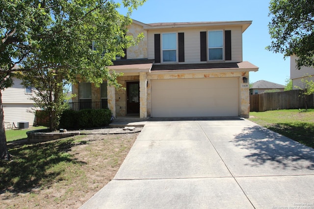 traditional-style home featuring concrete driveway, a front yard, central AC, a garage, and fence