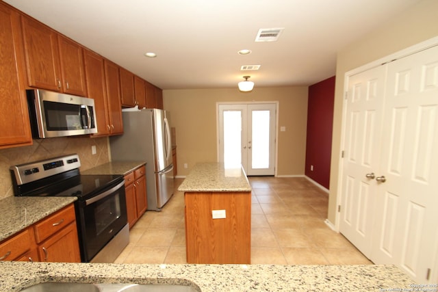 kitchen with a center island, backsplash, visible vents, and stainless steel appliances