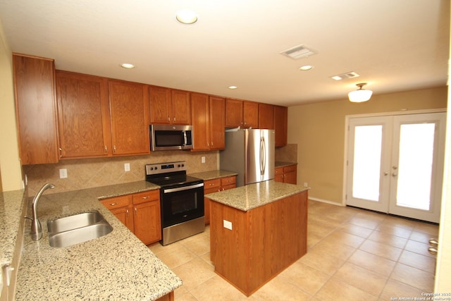 kitchen with a sink, visible vents, backsplash, and appliances with stainless steel finishes