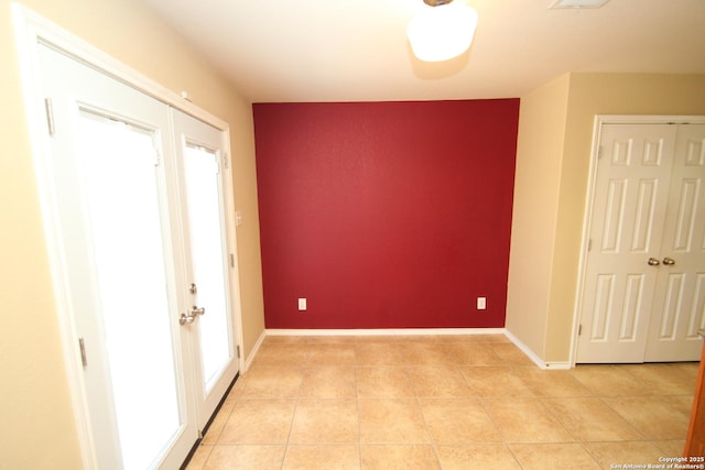 interior space featuring light tile patterned floors, baseboards, and a wealth of natural light