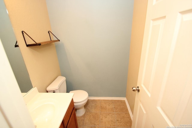 bathroom featuring toilet, tile patterned floors, vanity, and baseboards