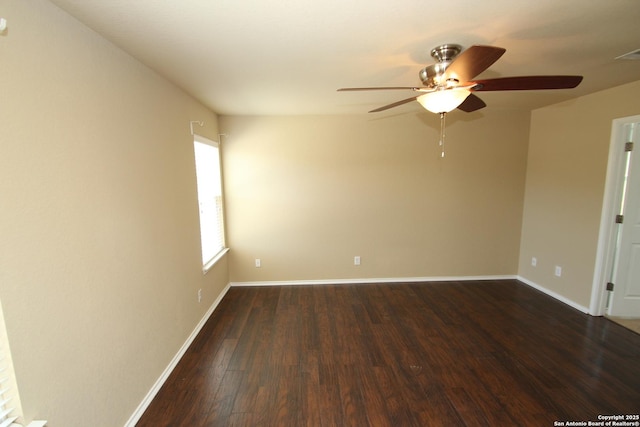 spare room featuring dark wood-style floors, baseboards, and a ceiling fan